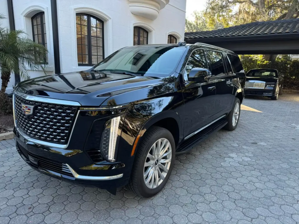 Black Cadillac Escalade SUV on a cobblestone driveway