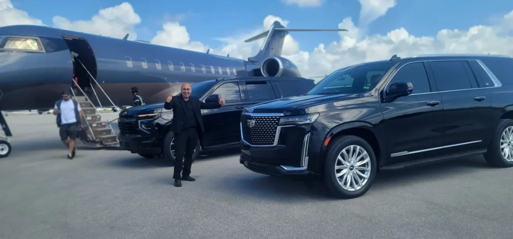 Black Cadillac SUV beside a private jet on an airport tarmac